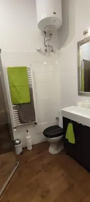 a bathroom with a toilet and a sink with a green towel at Quiet & Cosy Apt in the Heart of Old Cracow in Kraków