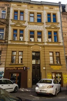 a building with two cars parked in front of it at Quiet & Cosy Apt in the Heart of Old Cracow in Kraków