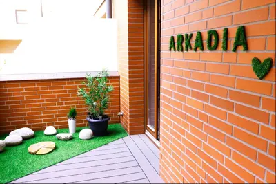 a garden with rocks on the side of a brick building at Apartament Arkadia na Kazimierzu in Kraków