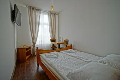 a bedroom with a bed and a desk and a window at Apartamenty Grodzka 8 in Kraków