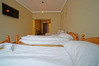a group of four beds in a room at Apartamenty Grodzka 8 in Kraków