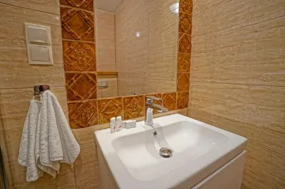 a bathroom with a white sink and a mirror at Apartamenty Grodzka 8 in Kraków