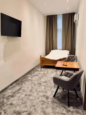 a bedroom with a bed and a table and a chair at Apartamenty Grodzka 8 in Kraków