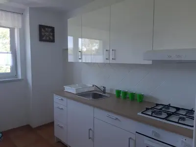 a kitchen with white cabinets and a sink and a stove at Agroturystyka Wichrowe Wzgorze in Osiek