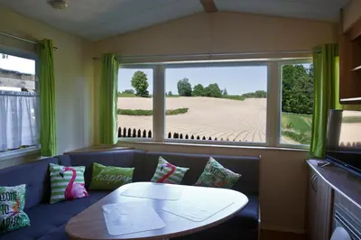 a living room with a couch and a table and a window at Agroturystyka Wichrowe Wzgorze in Osiek