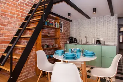 a kitchen with a brick wall and a table and chairs at BC7 Apartments in Kraków