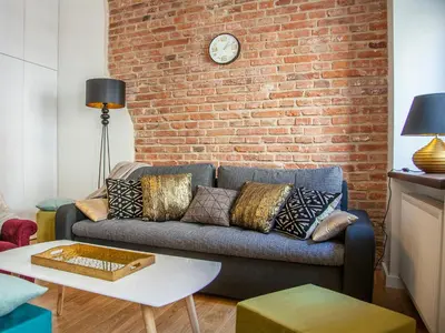 a living room with a couch and a brick wall at BC7 Apartments in Kraków