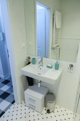 a white bathroom with a sink and a mirror at BC7 Apartments in Kraków