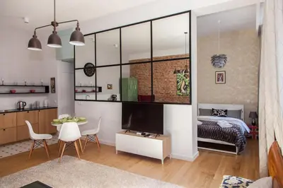a living room with a table and a television and a bedroom at BC7 Apartments in Kraków