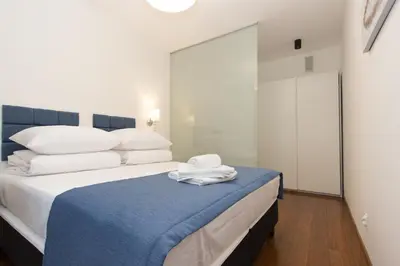 a bedroom with a bed with towels on it at Lenzo Apartments in Kraków