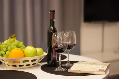a bottle of wine and two wine glasses on a table at Lenzo Apartments in Kraków