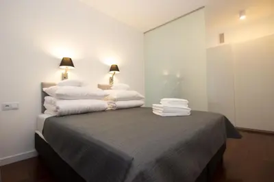 a bedroom with a pile of towels on a bed at Lenzo Apartments in Kraków