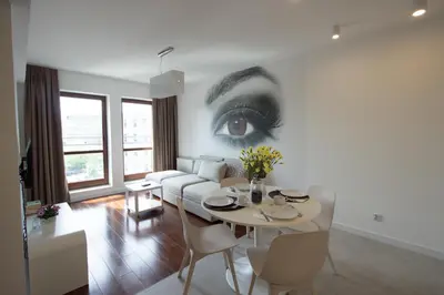 a living room with a drawing of an eye on the wall at Lenzo Apartments in Kraków