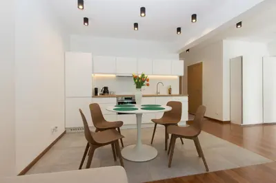 a kitchen and dining room with a table and chairs at Lenzo Apartments in Kraków