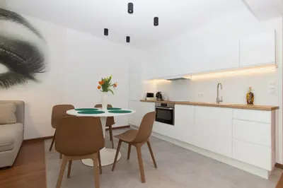 a kitchen and dining room with a table and chairs at Lenzo Apartments in Kraków