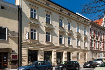 a large building with cars parked in front of it at Apartament nad dachami Krakowa in Kraków