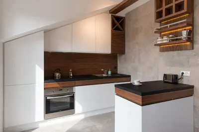 a kitchen with white cabinets and a black counter top at Apartament nad dachami Krakowa in Kraków