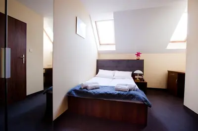 a bedroom with a bed with a blue comforter at Aparthotel W Pałacu in Kraków