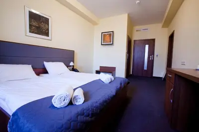 a hotel room with a bed with two pairs of shoes on it at Aparthotel W Pałacu in Kraków