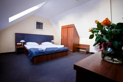 a bedroom with a bed and a vase of flowers at Aparthotel W Pałacu in Kraków