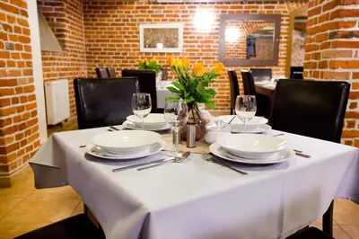 a white table with plates and glasses on it at Aparthotel W Pałacu in Kraków