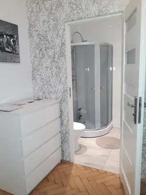 a white bathroom with a shower and a sink at Apartments Poland Kazimierz in Kraków