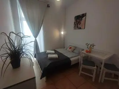 a bedroom with a bed and a table with a plant at Apartments Poland Kazimierz in Kraków