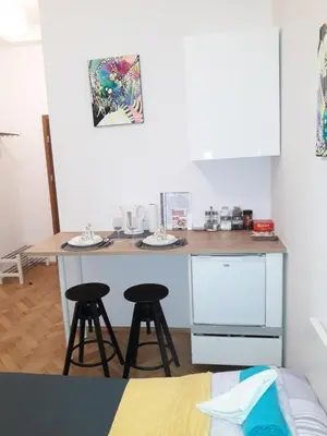 a kitchen with a table and two stools in a room at Apartments Poland Kazimierz in Kraków