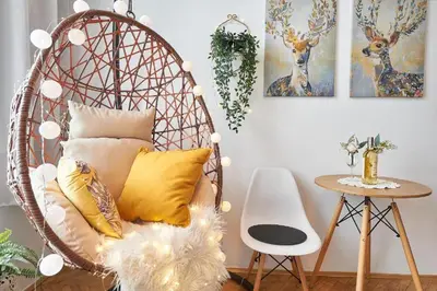 a rattan chair with pillows in a living room at Apartments Poland Kazimierz in Kraków