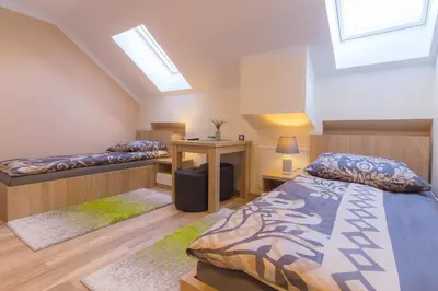 a bedroom with a bed and a table with a desk at Apartamenty Galeria Jordanowska in Jordanów