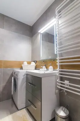 a washing machine in a bathroom with a sink at Apartamenty Galeria Jordanowska in Jordanów
