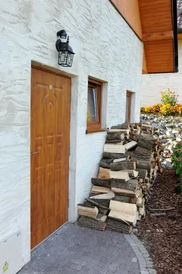 a building with a door and a pile of logs at Domki Oberwanka in Mszana Dolna