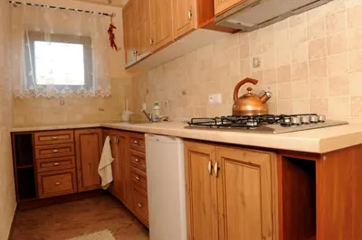 a kitchen with a stove and a tea kettle on the counter at Domki Oberwanka in Mszana Dolna