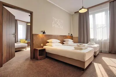 a hotel room with two beds and a mirror at Daniel Griffin Aparthotel by Artery Hotels in Kraków