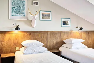 two beds in a hotel room with white pillows at Daniel Griffin Aparthotel by Artery Hotels in Kraków