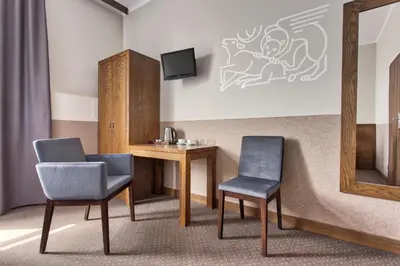 a room with two chairs and a table and a mirror at Daniel Griffin Aparthotel by Artery Hotels in Kraków