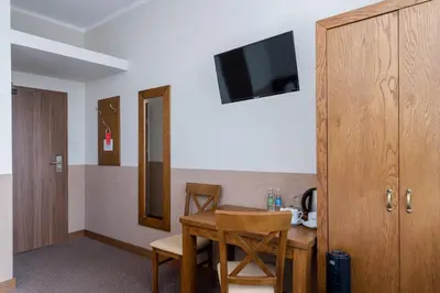 a room with a table and chairs and a television at Daniel Griffin Aparthotel by Artery Hotels in Kraków