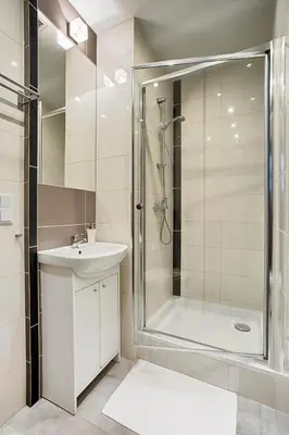a bathroom with a glass shower and a sink at Daniel Griffin Aparthotel by Artery Hotels in Kraków