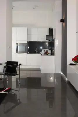 a kitchen with white cabinets and a table and a chair at Art Room Boutique Apartment in Kraków