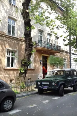a green jeep parked in front of a building at Art Room Boutique Apartment in Kraków