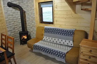a living room with a couch and a stove at U Kazika w górach in Ślemień