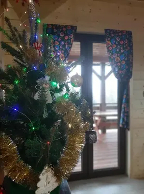 a christmas tree with lights on it in a room at U Kazika w górach in Ślemień