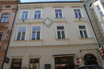 a building with a clock on the side of it at Pokoje Gościnne Wiślna in Kraków