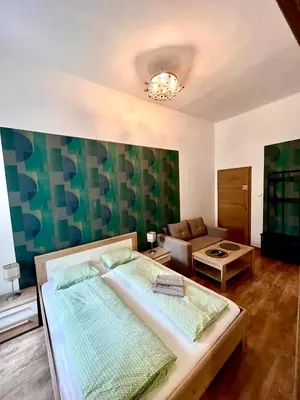 a bedroom with a large bed and a couch at Pokoje Gościnne Wiślna in Kraków