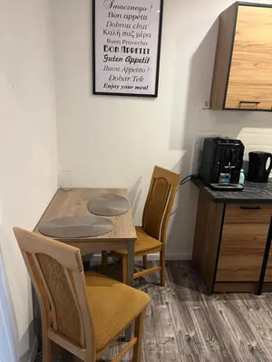 a kitchen with a table and chairs and a microwave at Pokoje Gościnne Wiślna in Kraków