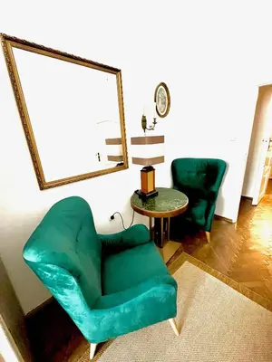 a living room with a green chair and a table at Pokoje Gościnne Wiślna in Kraków