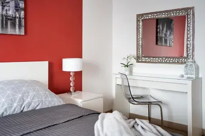 a bedroom with a bed and a mirror on a wall at Jack Apartment in Kraków