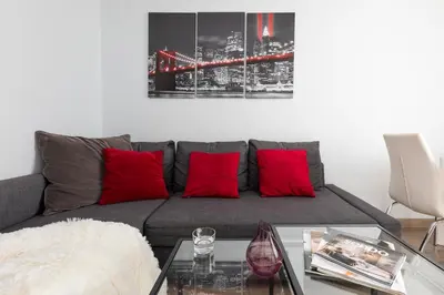 a living room with a gray couch with red pillows at Jack Apartment in Kraków