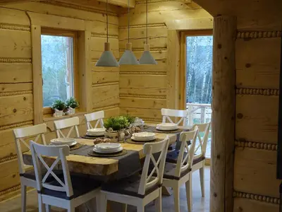 a dining room with a wooden table and chairs at Domki Zawoja z Jacuzzi in Zawoja