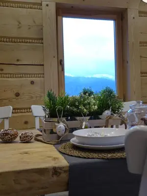 a table with a white plate on a table with a window at Domki Zawoja z Jacuzzi in Zawoja